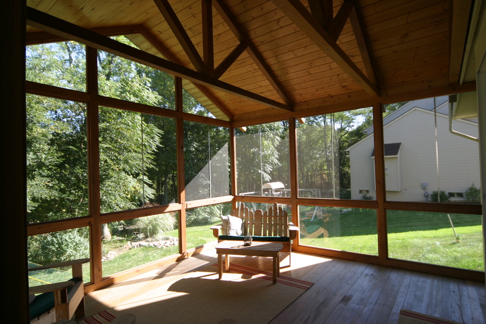 Idéer för en stor klassisk innätad veranda på baksidan av huset, med trädäck och takförlängning
