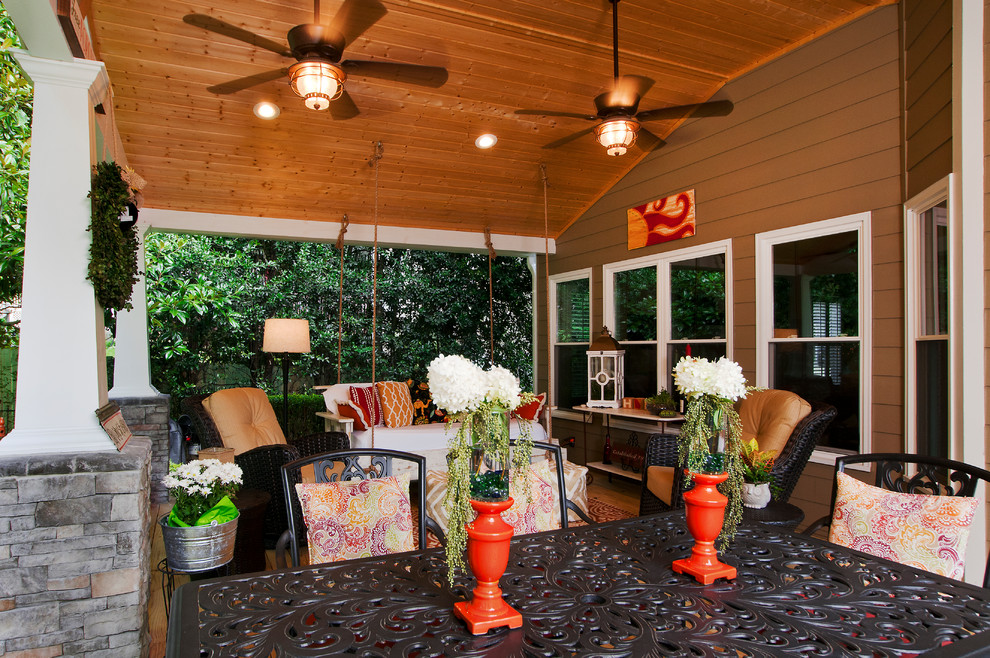 Idée de décoration pour un porche d'entrée de maison arrière craftsman de taille moyenne avec une terrasse en bois et une extension de toiture.