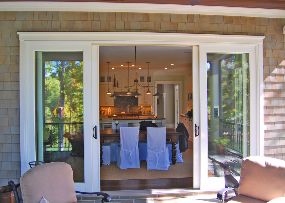 Klassisk inredning av en stor veranda på baksidan av huset, med naturstensplattor och takförlängning