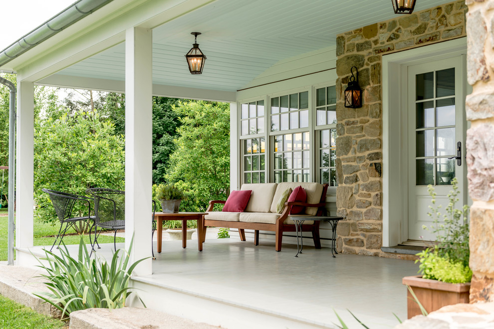 Inspiration pour un porche d'entrée de maison arrière traditionnel avec une extension de toiture et une terrasse en bois.