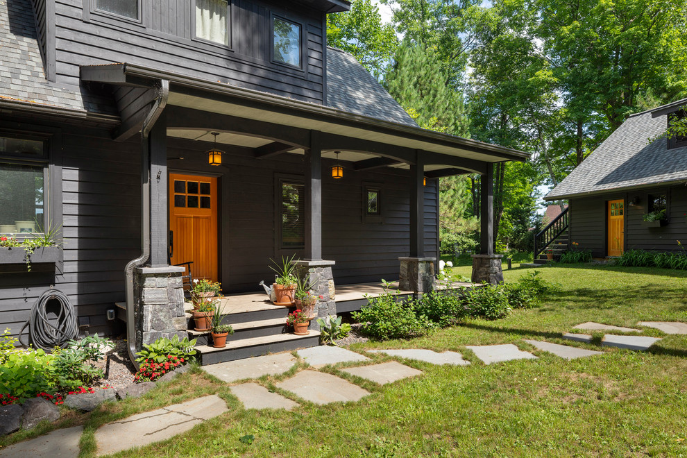 Idée de décoration pour un porche d'entrée de maison avant chalet avec des pavés en pierre naturelle et une extension de toiture.