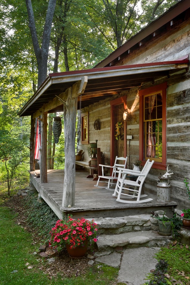 Exempel på en rustik veranda framför huset, med trädäck och takförlängning