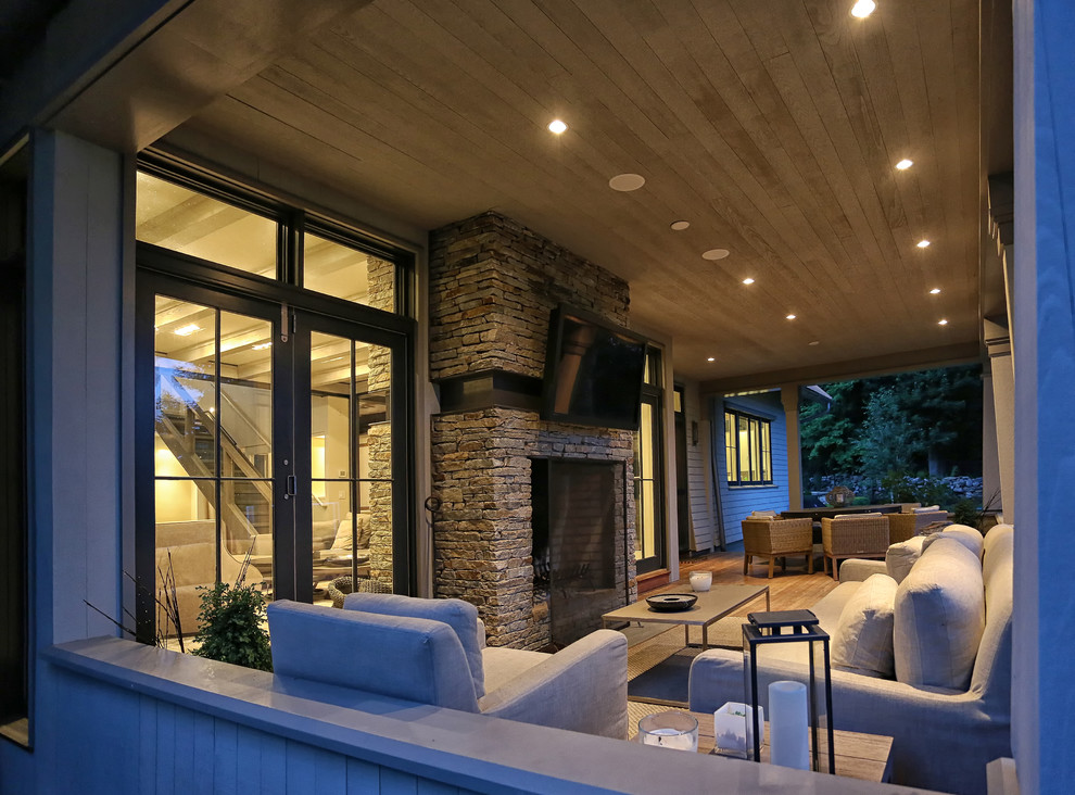 Aménagement d'un porche d'entrée de maison arrière moderne de taille moyenne avec un foyer extérieur et une extension de toiture.