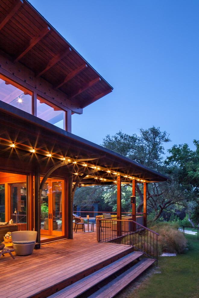 Design ideas for a rustic veranda in Austin with decking, a roof extension and feature lighting.