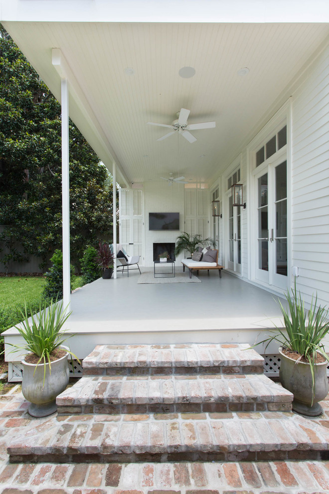 Cette photo montre un porche d'entrée de maison arrière tendance de taille moyenne avec un foyer extérieur, des pavés en brique et une extension de toiture.