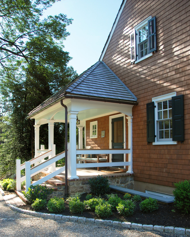 Réalisation d'un grand porche d'entrée de maison avant tradition avec des pavés en brique et une extension de toiture.