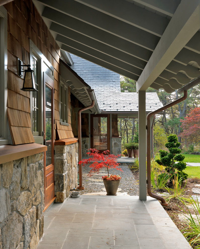 Idee per un portico american style di medie dimensioni e davanti casa con un giardino in vaso, pavimentazioni in cemento e un tetto a sbalzo