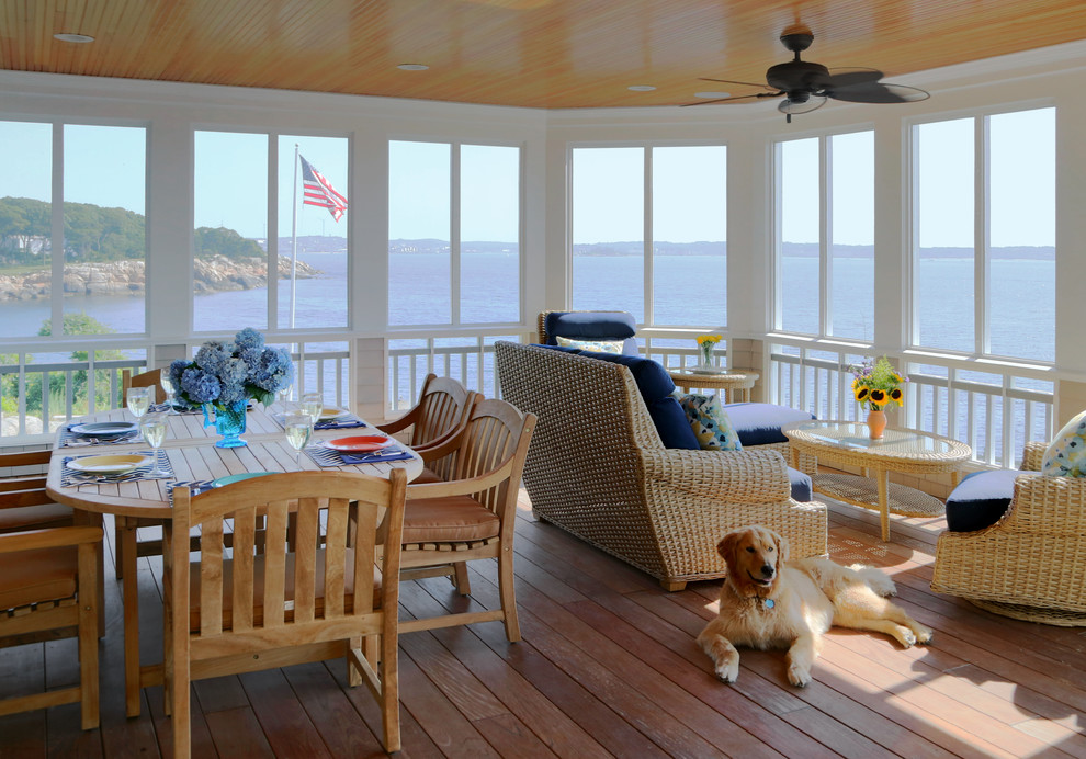 Idée de décoration pour un porche d'entrée de maison marin avec une terrasse en bois, une extension de toiture et une moustiquaire.