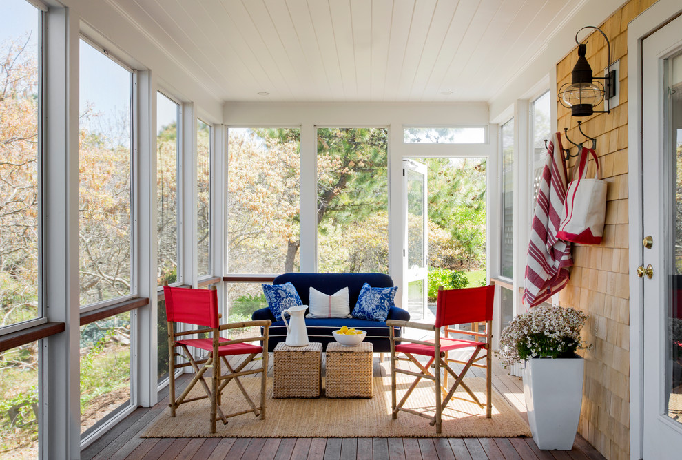 Inspiration for a mid-sized coastal screened-in porch remodel in Boston with decking and a roof extension