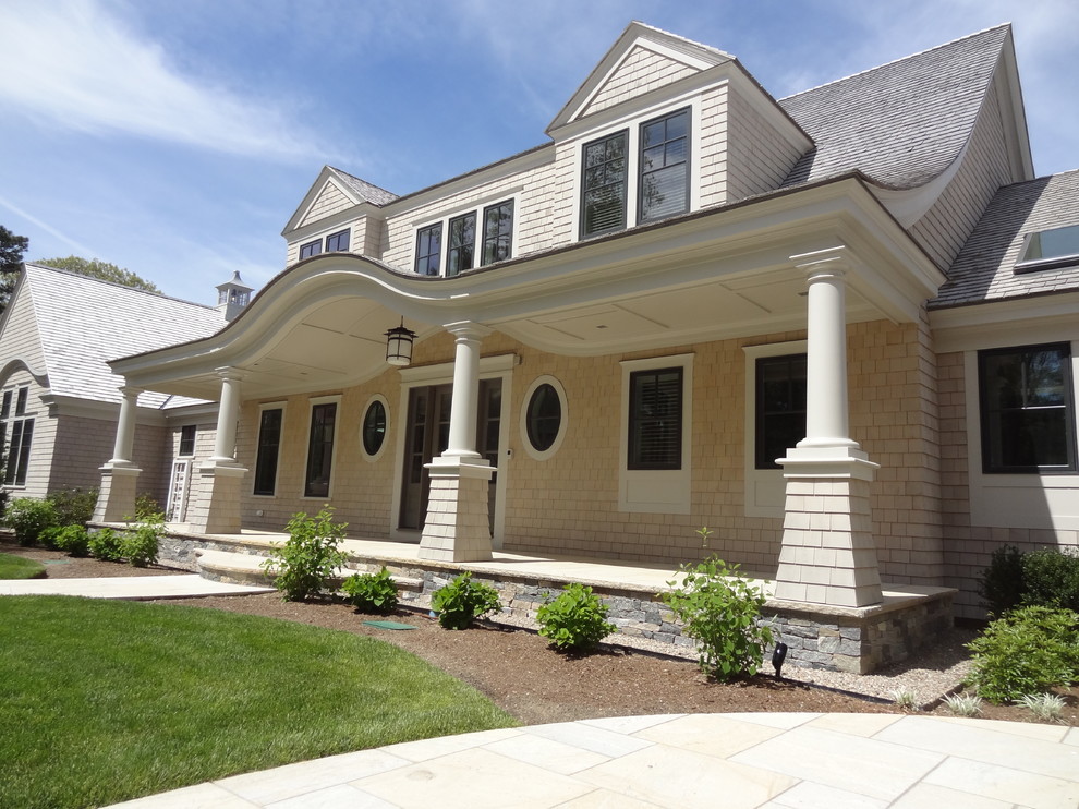 This is an example of a mid-sized traditional stone front porch design in Boston with a roof extension.