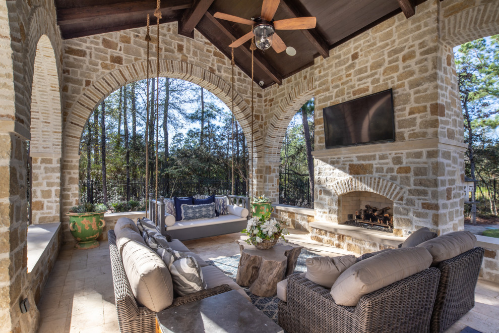 This is an example of a mediterranean veranda in Houston with a fireplace.
