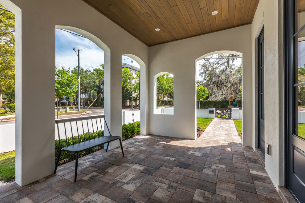 Medium sized world-inspired front veranda in Orlando with an outdoor kitchen, brick paving and a roof extension.