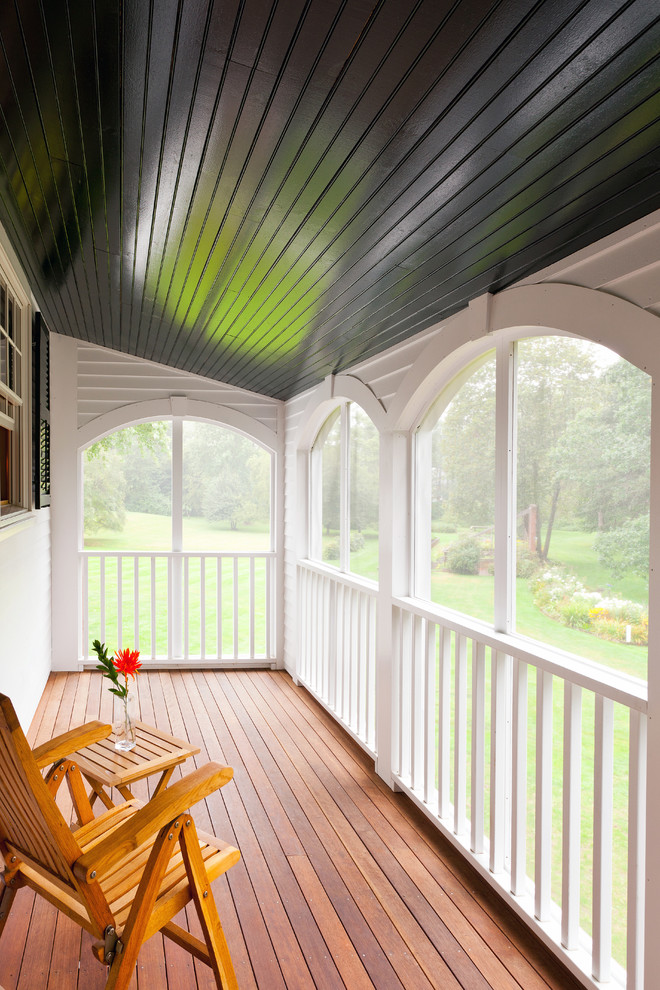 Photo of a traditional screened veranda in Boston with decking and a roof extension.