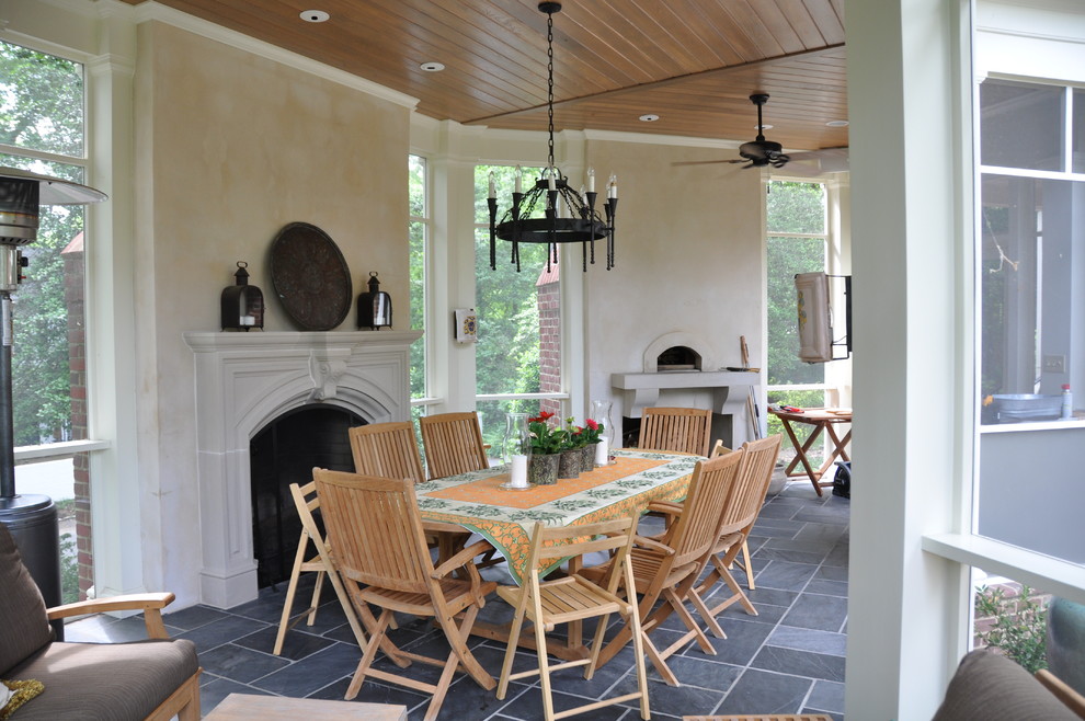 Inspiration pour un grand porche d'entrée de maison latéral traditionnel avec une cheminée, des pavés en pierre naturelle et une extension de toiture.