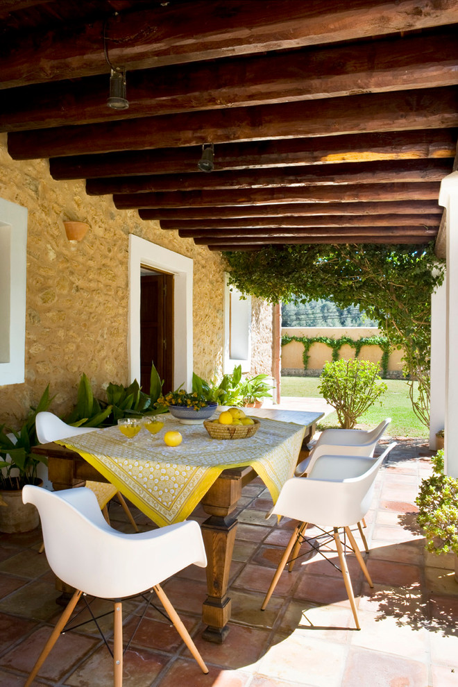 Idee per un portico mediterraneo di medie dimensioni e dietro casa con un giardino in vaso, piastrelle e un tetto a sbalzo