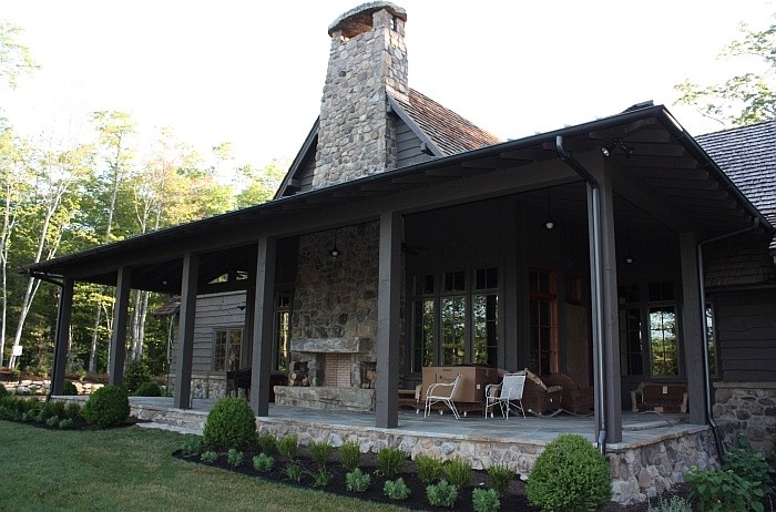 Exempel på en rustik veranda, med naturstensplattor och takförlängning