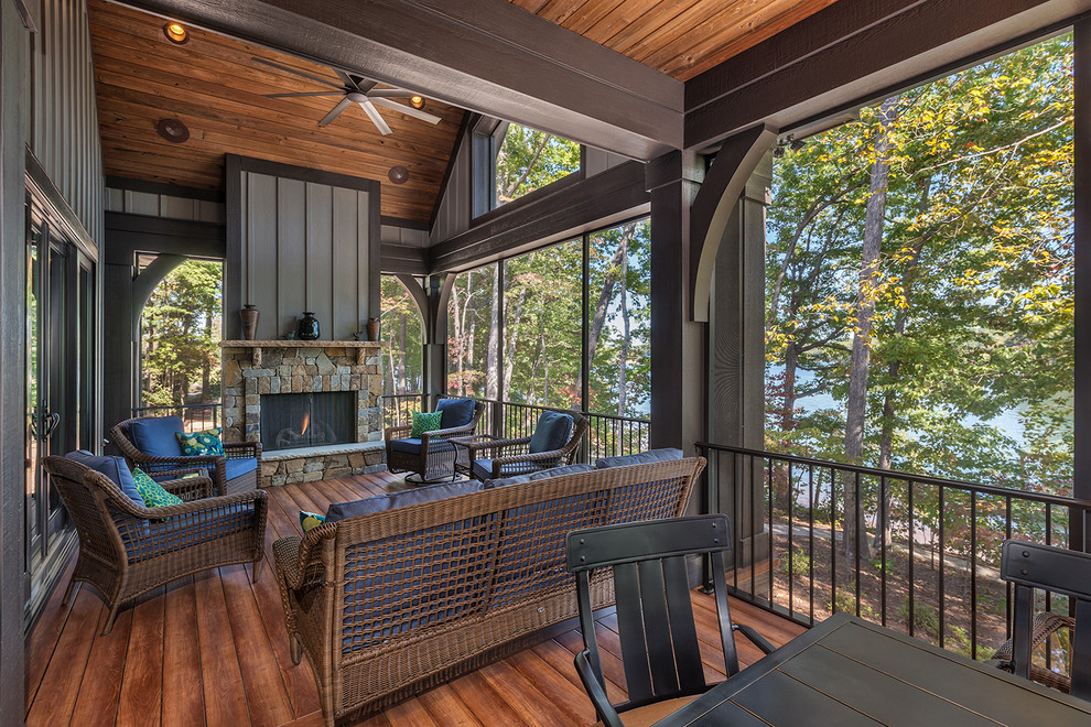 Inspiration pour un grand porche d'entrée de maison arrière craftsman avec une moustiquaire, une terrasse en bois et une extension de toiture.