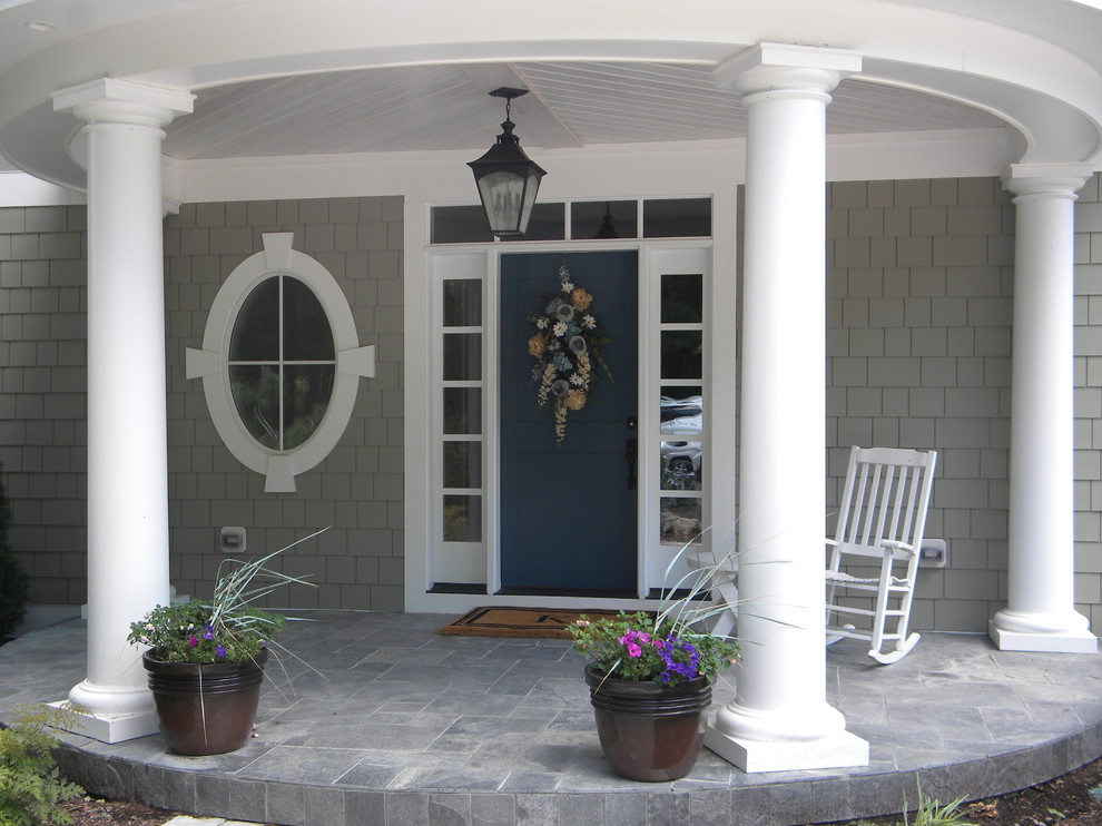 Inspiration for a mid-sized timeless concrete paver front porch remodel in Cleveland with a roof extension