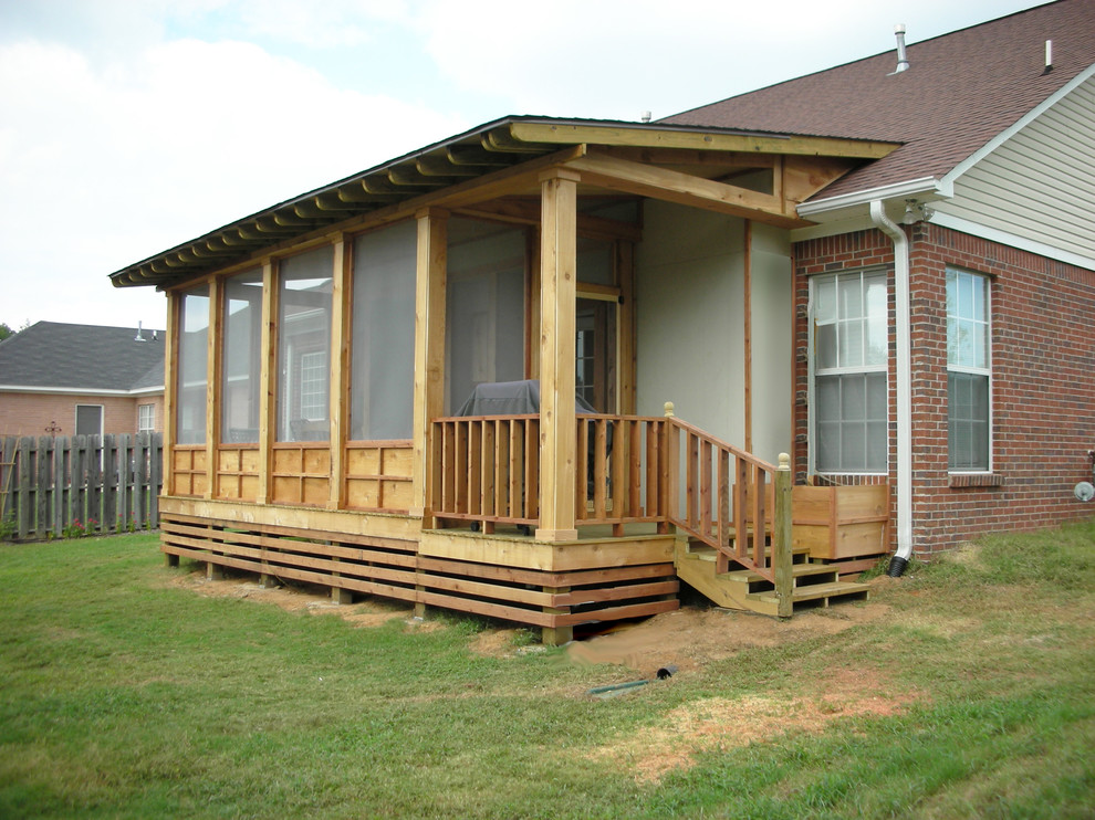 Réalisation d'un porche d'entrée de maison arrière chalet de taille moyenne avec une moustiquaire, une terrasse en bois et une extension de toiture.