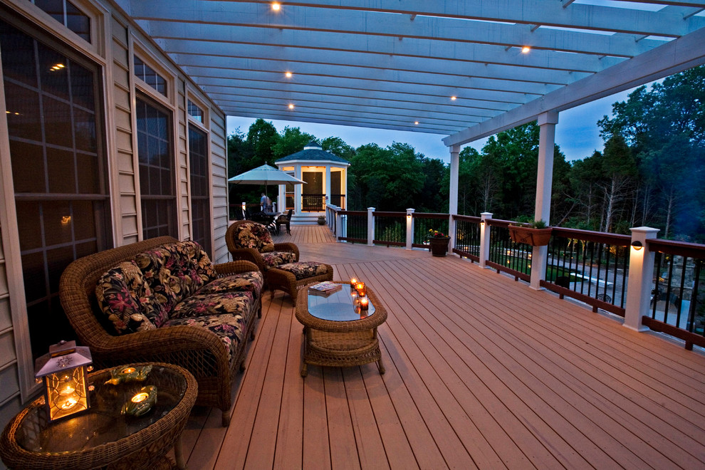Idée de décoration pour un très grand porche d'entrée de maison arrière tradition avec une terrasse en bois et une pergola.