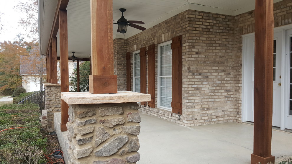 Cette image montre un grand porche d'entrée de maison avant craftsman avec une dalle de béton et une extension de toiture.