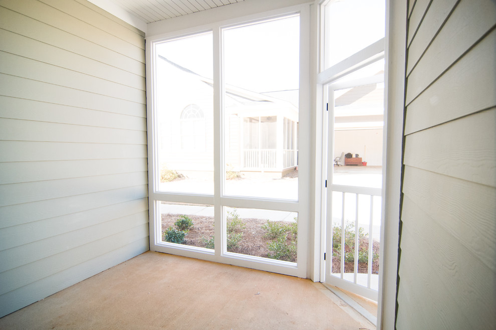 Foto di un piccolo portico classico nel cortile laterale con un portico chiuso, lastre di cemento e un tetto a sbalzo