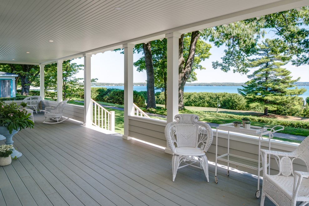 Idées déco pour un grand porche d'entrée de maison avant bord de mer avec une terrasse en bois et une extension de toiture.