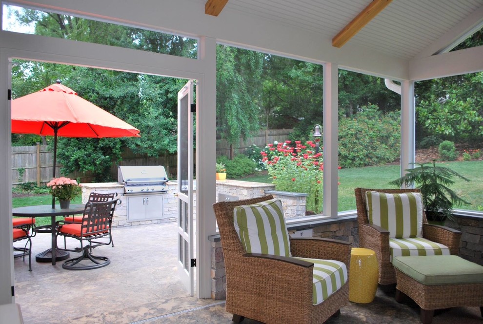 This is an example of a large traditional screened-in back porch design in Other.