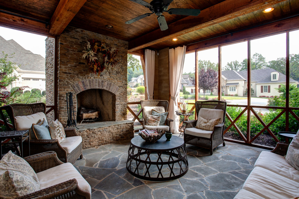 Inspiration for a mid-sized timeless stone back porch remodel in Little Rock with a fire pit and a roof extension