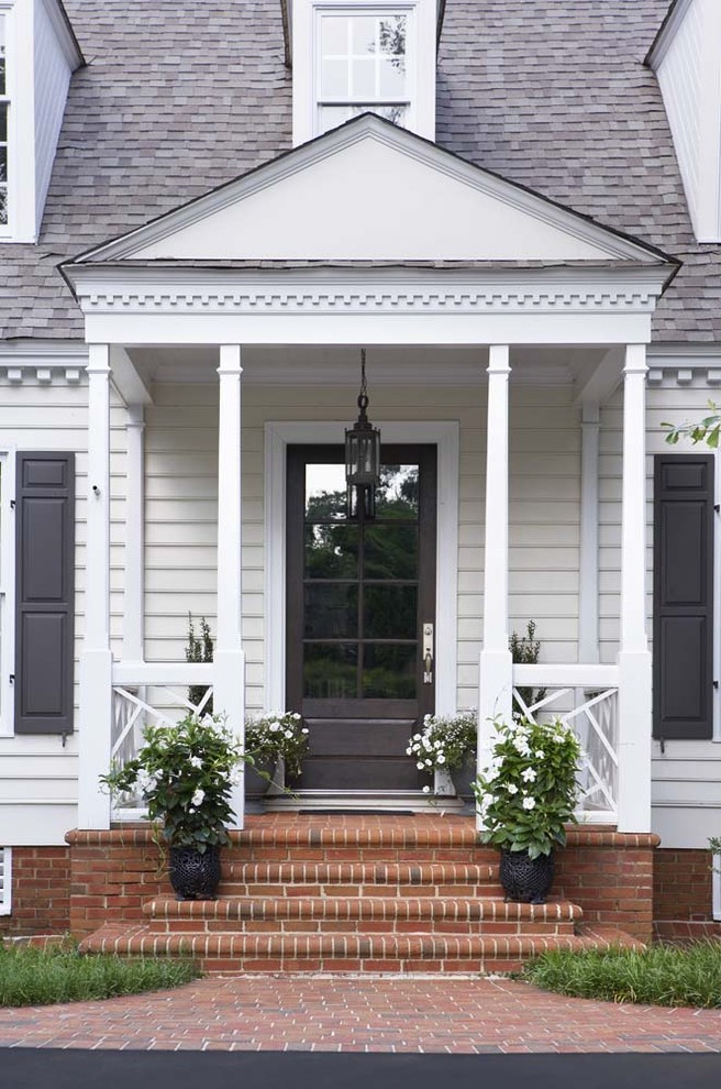 Idee per un piccolo portico chic davanti casa con un giardino in vaso, pavimentazioni in mattoni e un tetto a sbalzo