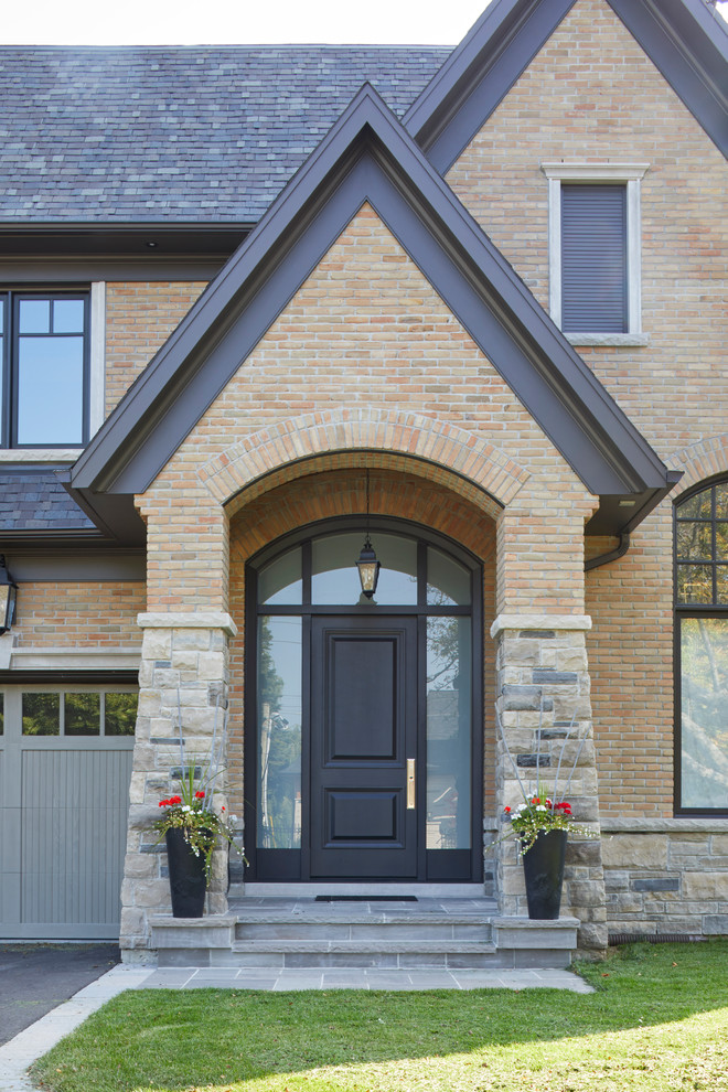 Immagine di un portico chic di medie dimensioni e davanti casa con pavimentazioni in pietra naturale e un tetto a sbalzo