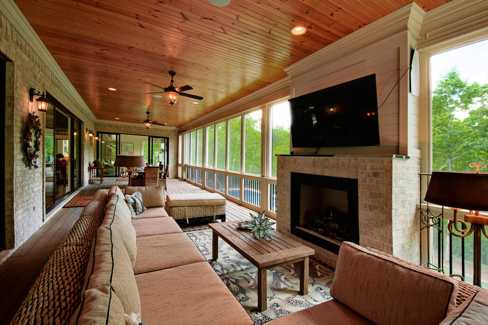 Inspiration for a huge transitional screened-in side porch remodel in Other with decking and a roof extension