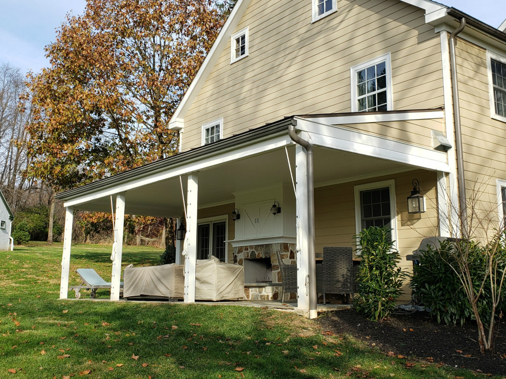 Exemple d'un grand porche d'entrée de maison arrière nature avec une moustiquaire et un auvent.