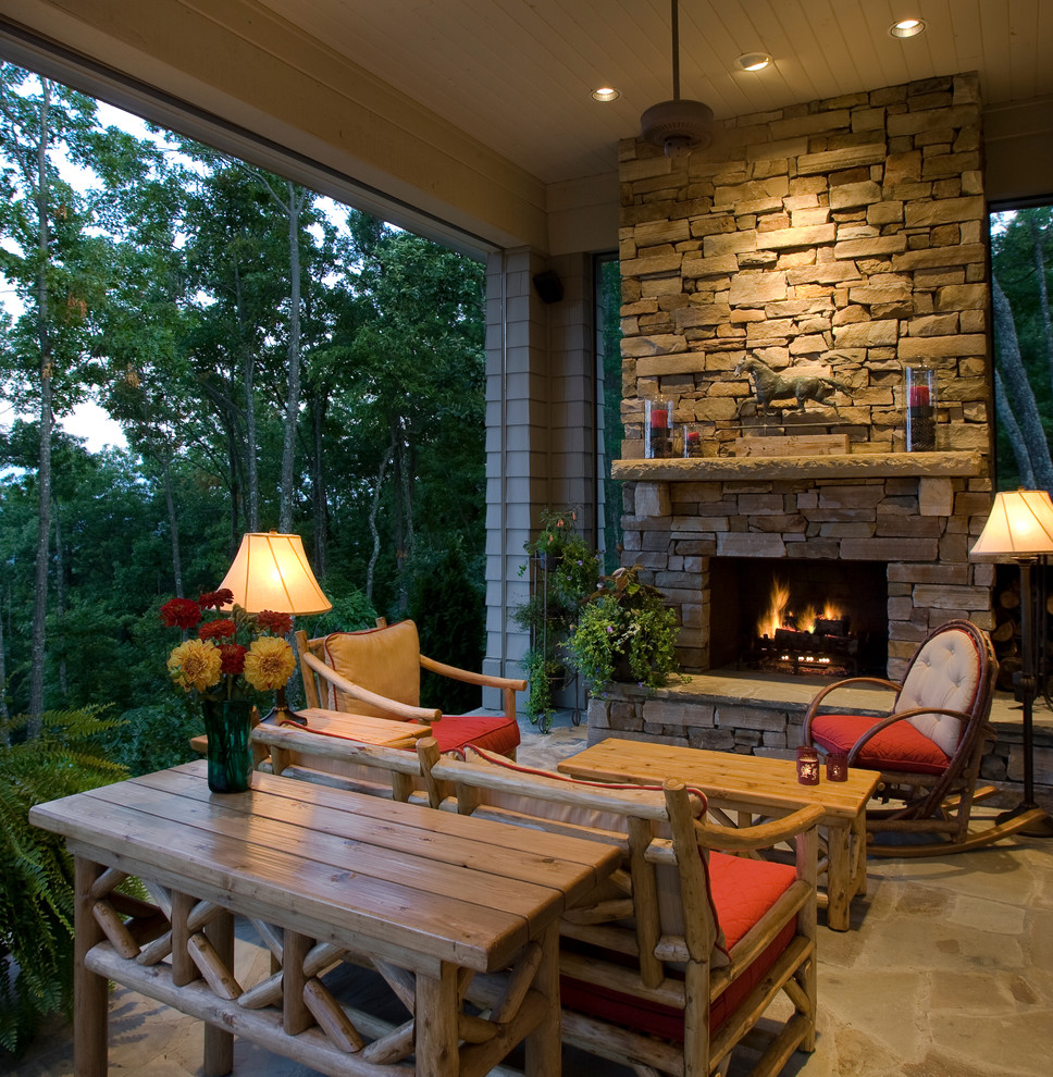 Inspiration for a rustic stone porch remodel in Other with a fire pit