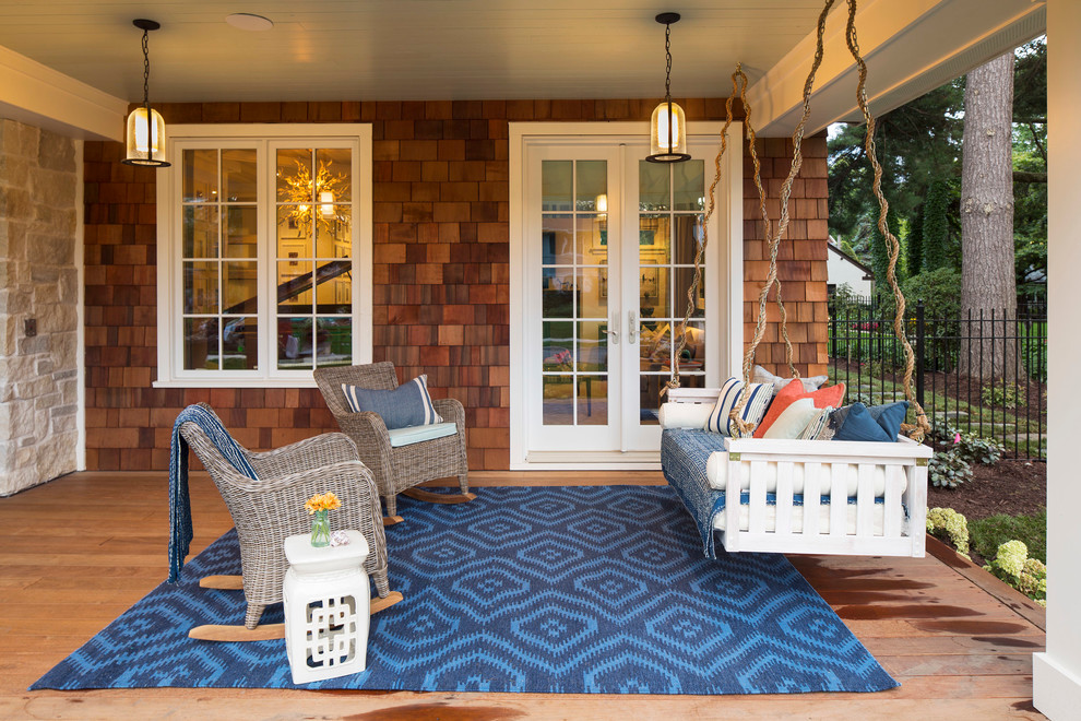 Large beach style front porch idea in Minneapolis with a roof extension