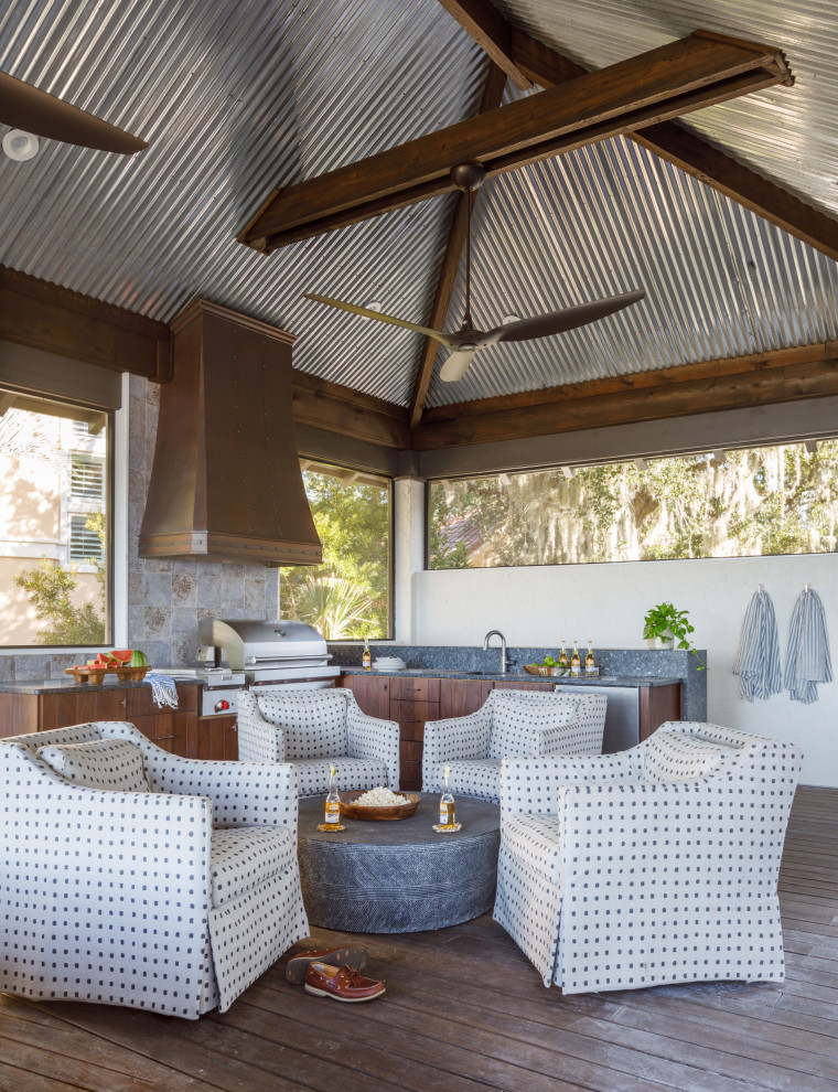 Cette image montre un très grand porche d'entrée de maison arrière méditerranéen avec une cuisine d'été, une terrasse en bois et une extension de toiture.