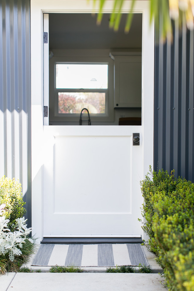 Idée de décoration pour un petit porche d'entrée de maison avant champêtre avec une dalle de béton.