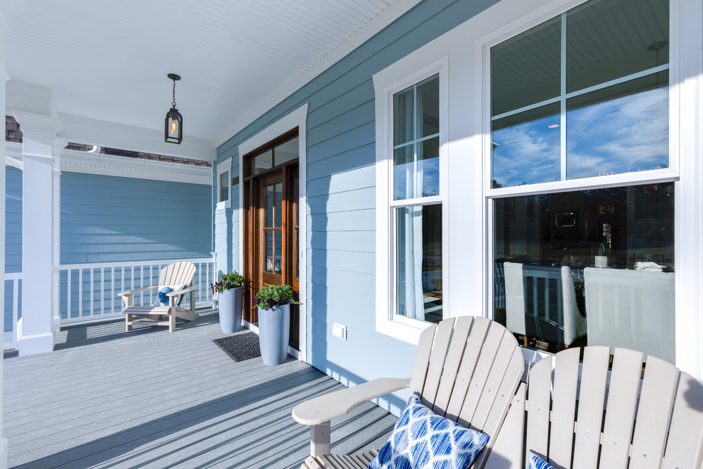 Cette photo montre un grand porche d'entrée de maison avant bord de mer avec une extension de toiture.