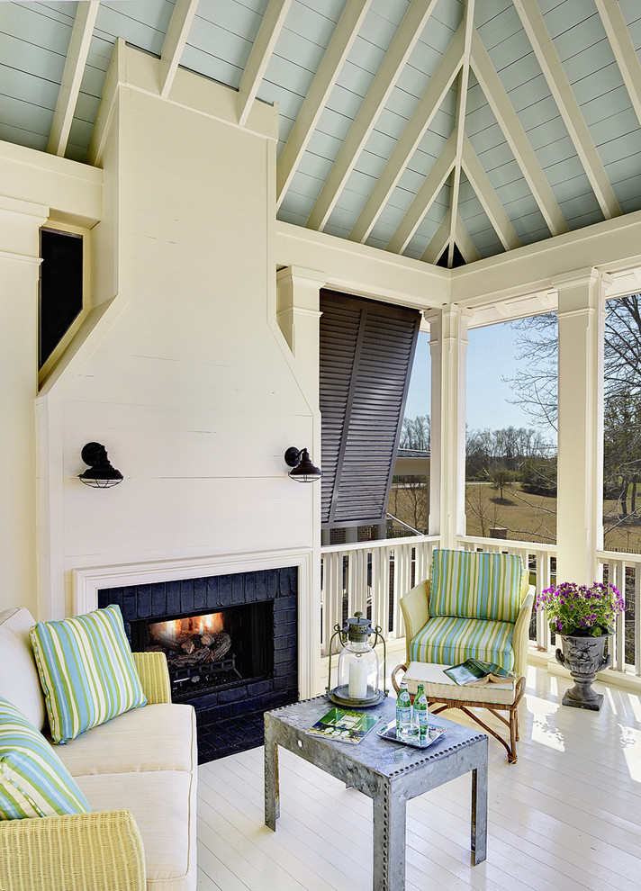 This is an example of a tropical porch design in Charleston with a fire pit.