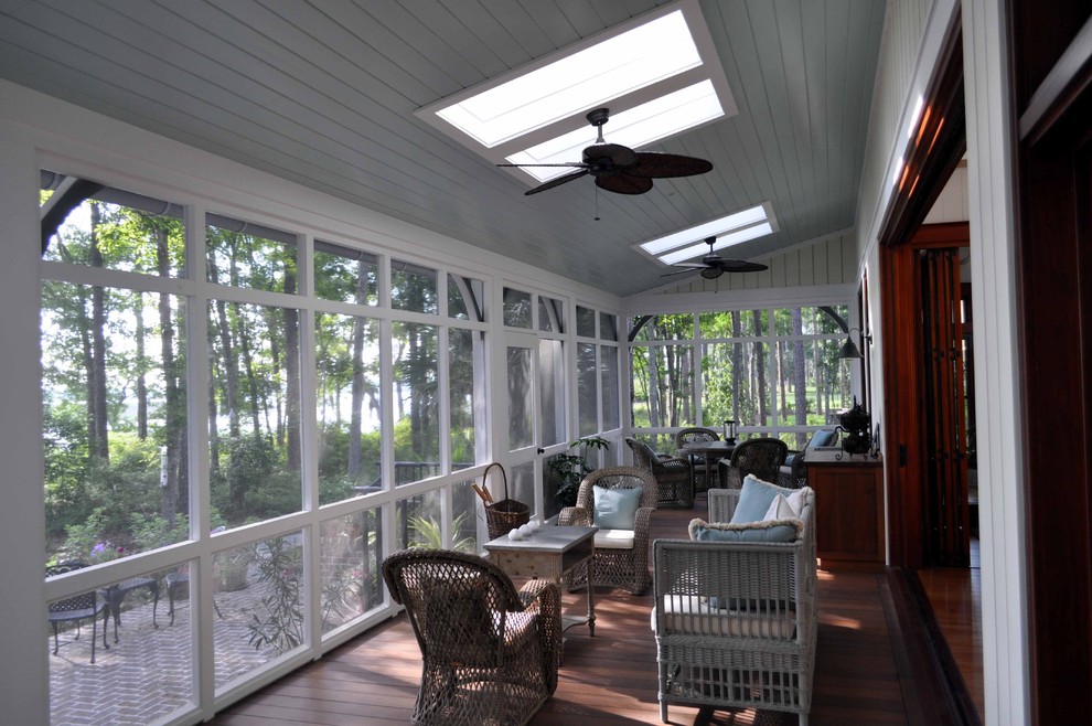 Exemple d'un grand porche d'entrée de maison arrière chic avec une moustiquaire, une terrasse en bois et une extension de toiture.