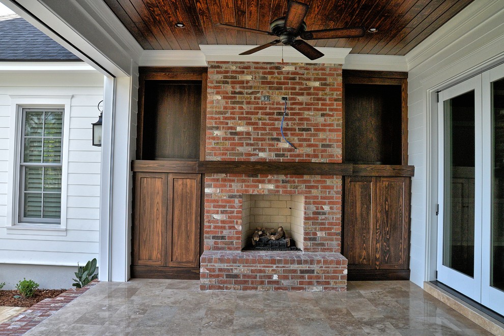 Exemple d'un grand porche d'entrée de maison arrière bord de mer avec des pavés en pierre naturelle et une extension de toiture.