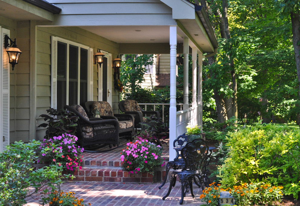 Diseño de terraza tradicional de tamaño medio en patio delantero con jardín de macetas y adoquines de ladrillo