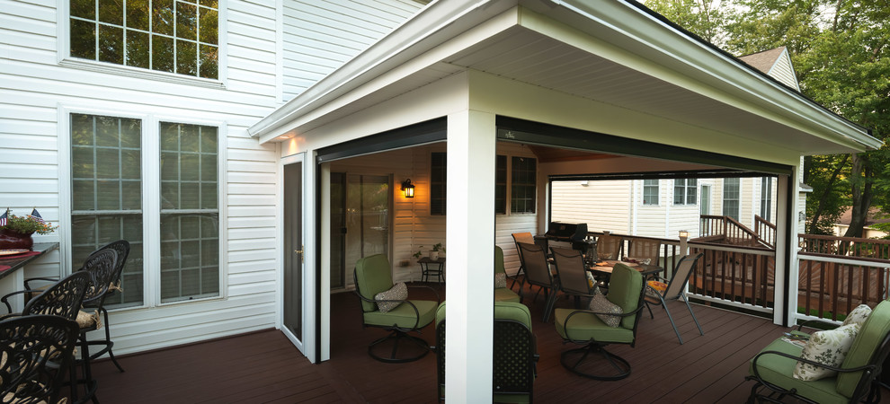 This is an example of a mid-sized traditional porch design in DC Metro with decking and a roof extension.
