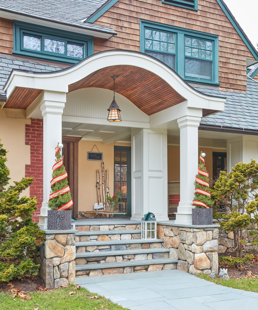 This is an example of a mid-sized craftsman concrete front porch design in Boston with a roof extension.