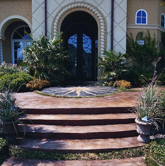 Cette photo montre un grand porche d'entrée de maison avant méditerranéen avec des pavés en béton.