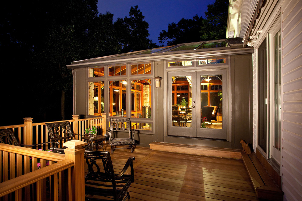 Exemple d'un porche d'entrée de maison arrière tendance de taille moyenne avec une terrasse en bois, une moustiquaire et une extension de toiture.