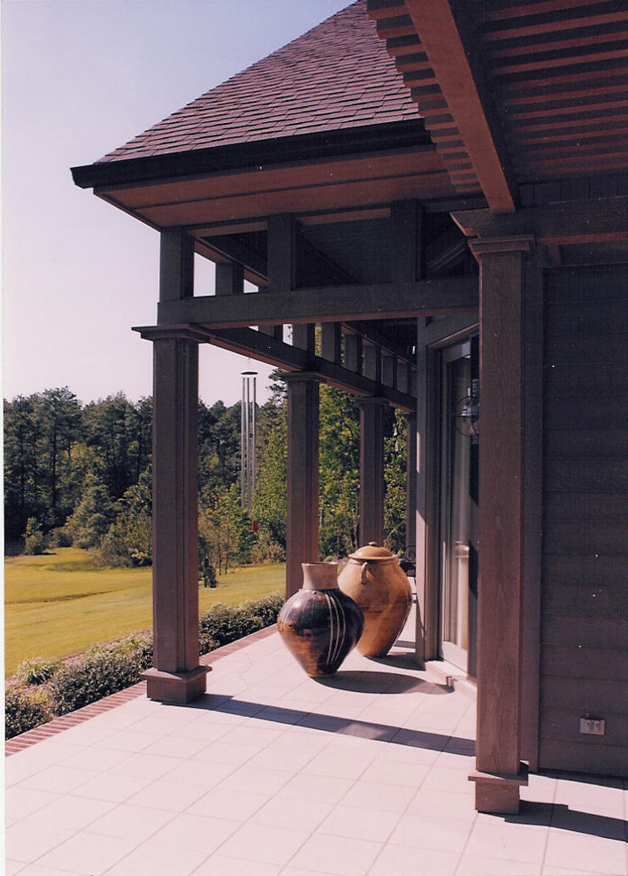 На фото: большая веранда на переднем дворе в стиле кантри с покрытием из плитки и навесом с