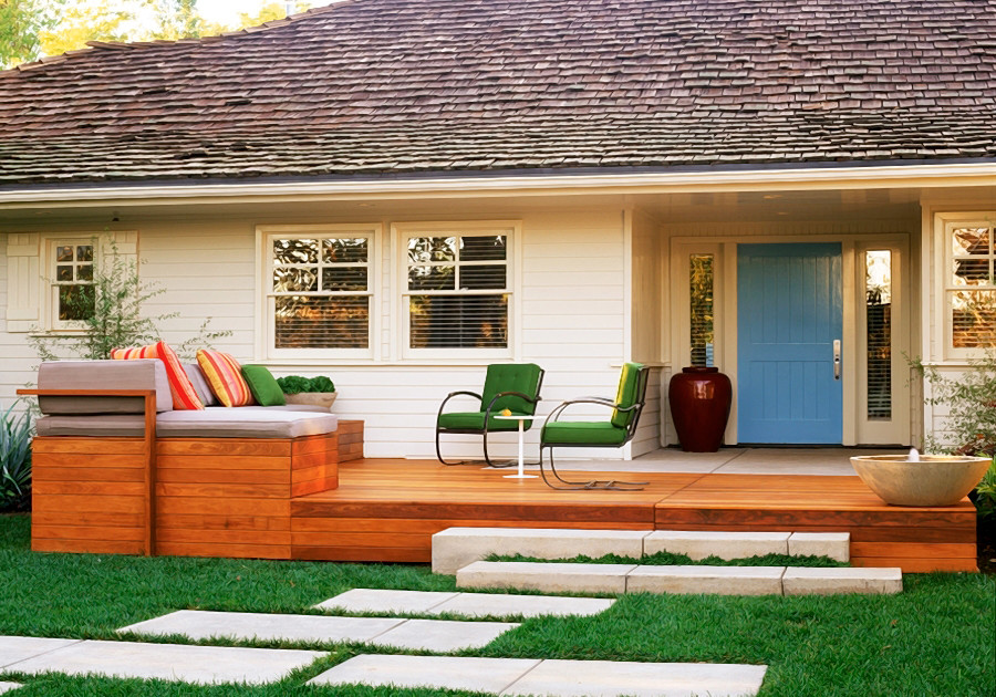 Cette image montre un grand porche d'entrée de maison avant design avec une terrasse en bois.