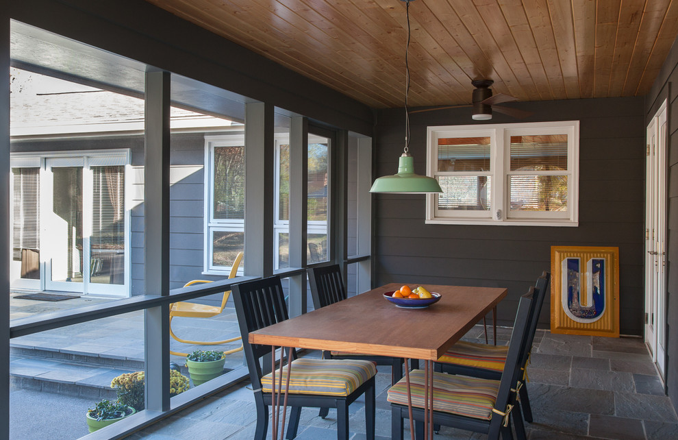 Cette image montre un porche d'entrée de maison arrière minimaliste de taille moyenne avec une moustiquaire, des pavés en pierre naturelle et une extension de toiture.