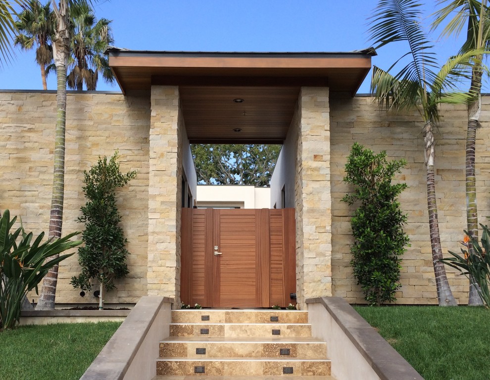 Aménagement d'un porche d'entrée de maison avant exotique de taille moyenne avec du carrelage et une extension de toiture.